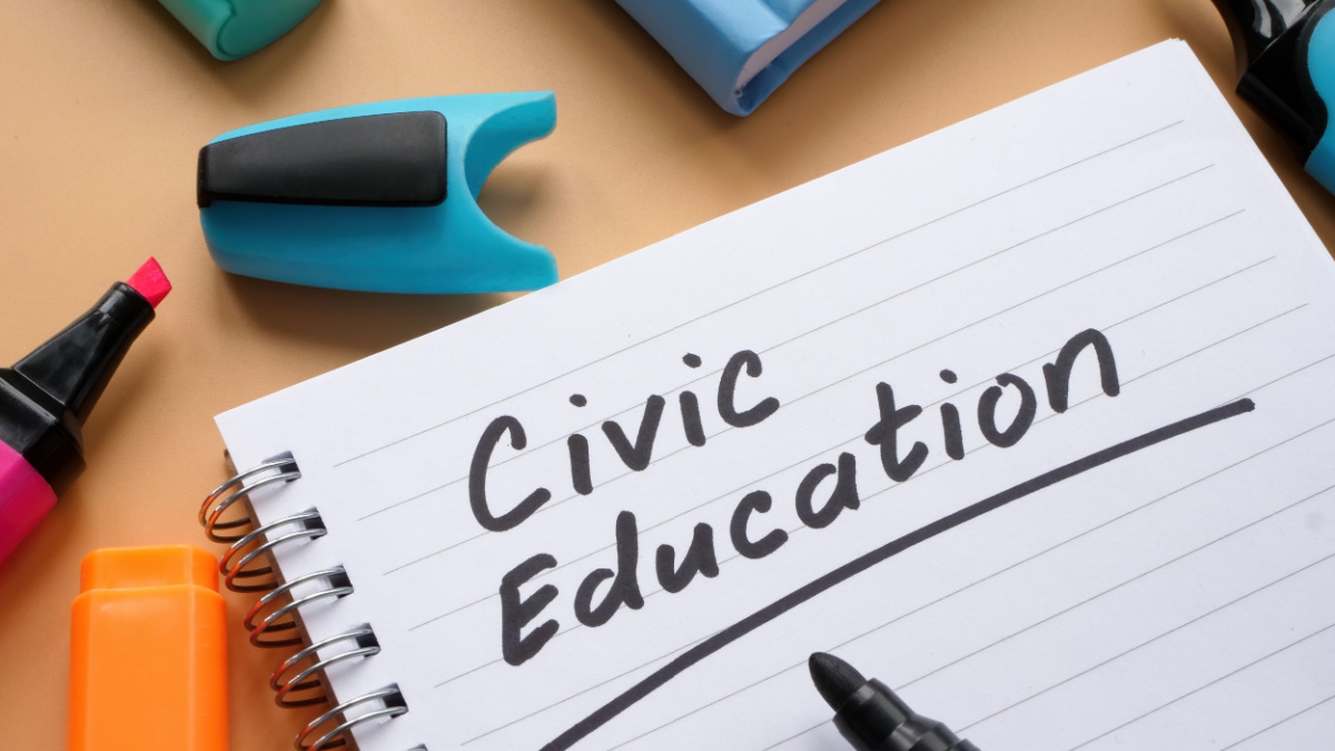 Open notebook with words civic education and marker.