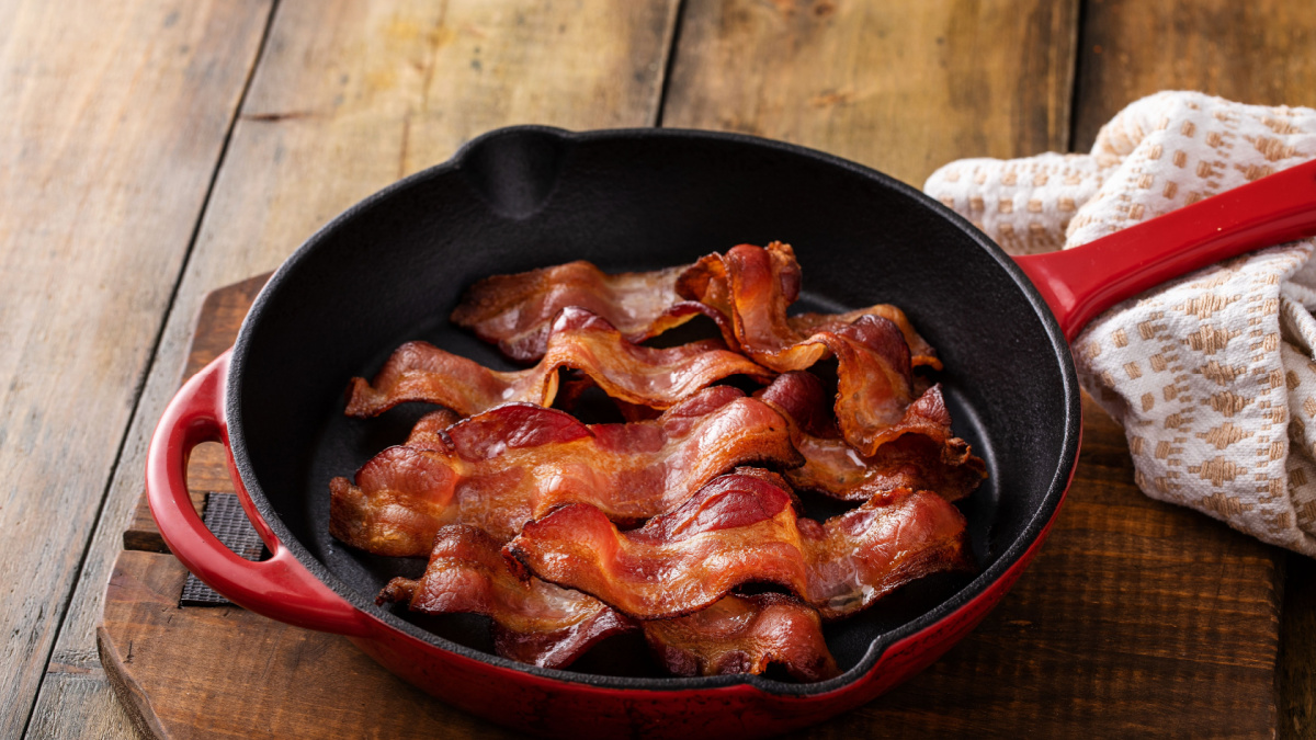 Cooked bacon in a cast iron pan, ready to eat breakfast staple