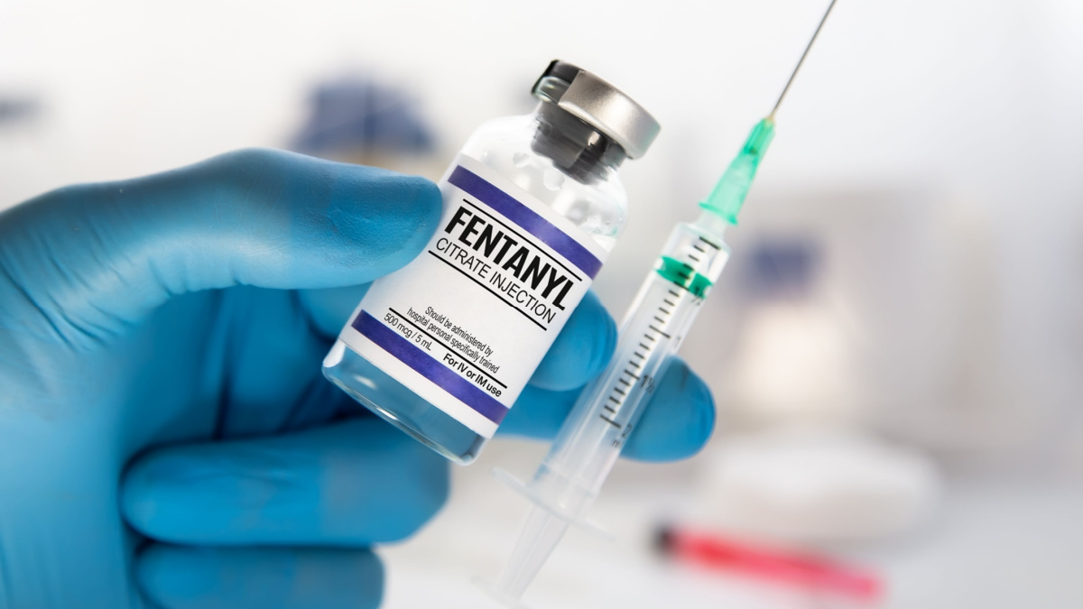 Professional with vial and injection of dose of Fentanyl Citrate Solution for analgesic treatment. Doctor holding injection of medication of Fentanyl is opioid used to palliate pain or for anesthetic