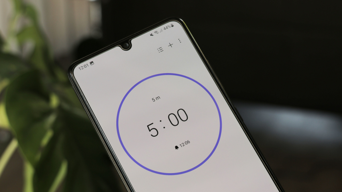 A phone with a white 5-minute timer on a blurry background