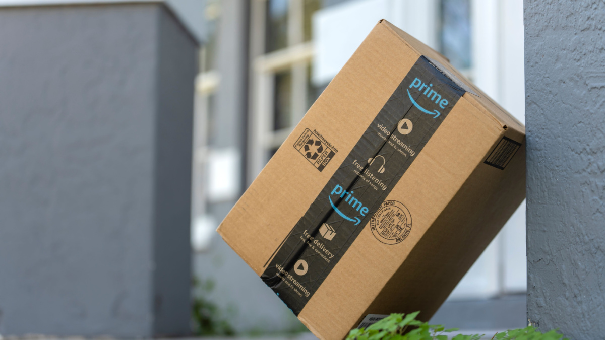 Amazon Prime package box with purchased online products delivered in front of house door. Amazon Prime priority delivery. E-commerce concept. Sarasota, USA - December 19, 2022.
