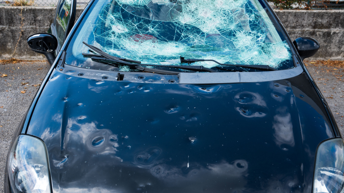 hail damage to car. damaged hood and windshield.