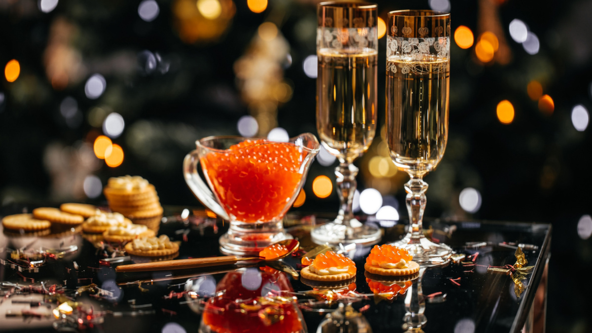 glass of champagne with red caviar appetizer cracker, butter and red caviar. banner, menu, recipe.