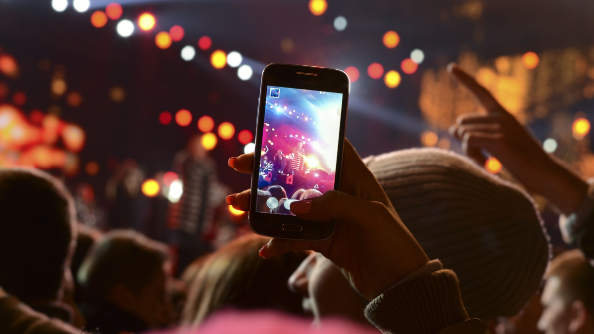 People holding their smart phones and photographing concert.