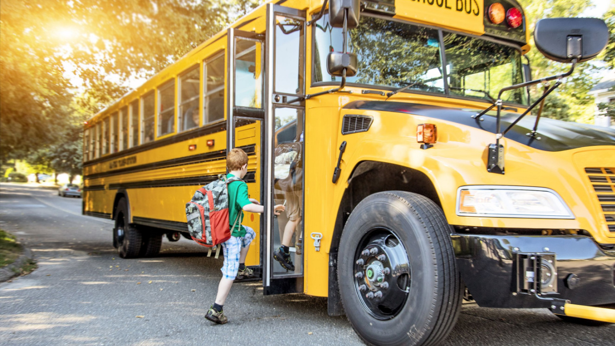 A group of young children getting on the schoolbus