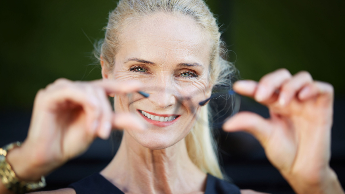 Happy businesswoman holding glasses.