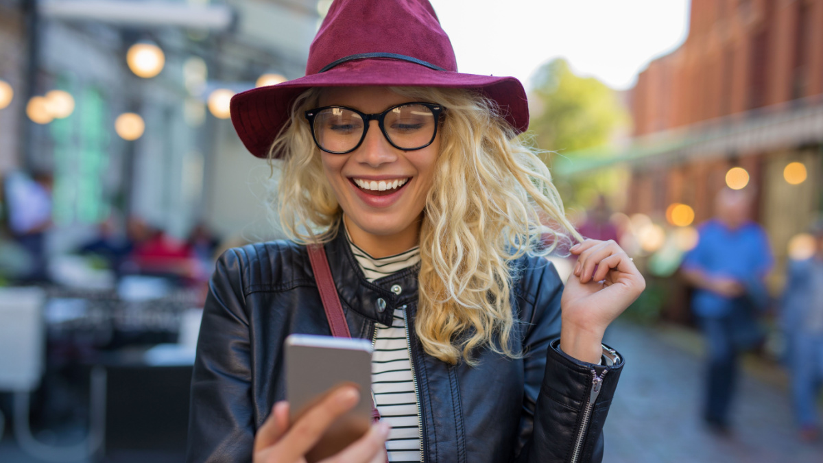 Happy and funny woman looking at her phone.