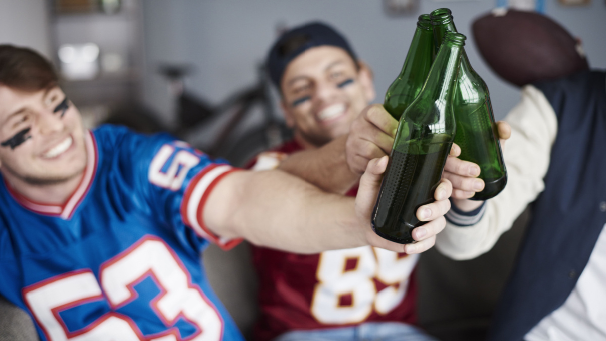 American football fans make a toast indoors.