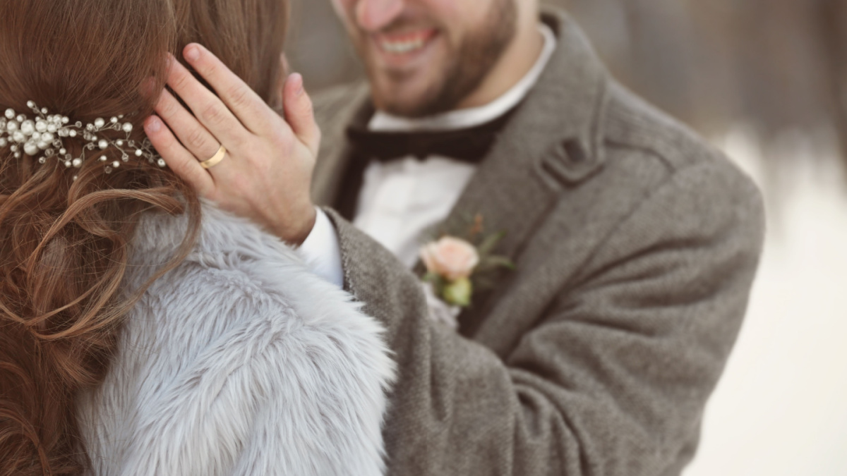 Happy wedding couple outdoors on winter day, closeup.