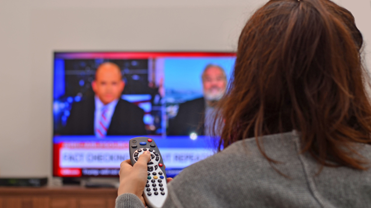 Women watching tv and use remote controller.