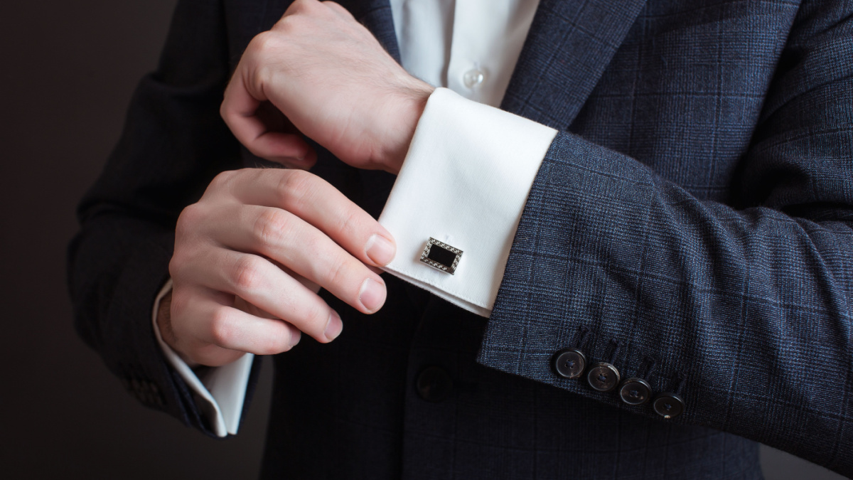 Close-up of a man in a tux fixing his cufflink. groom bow tie cufflinks