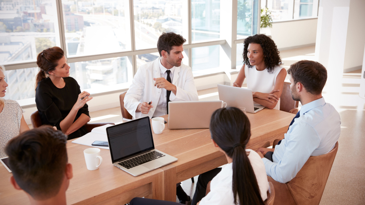 Group Of Medical Staff Meeting Around Table In Hospital