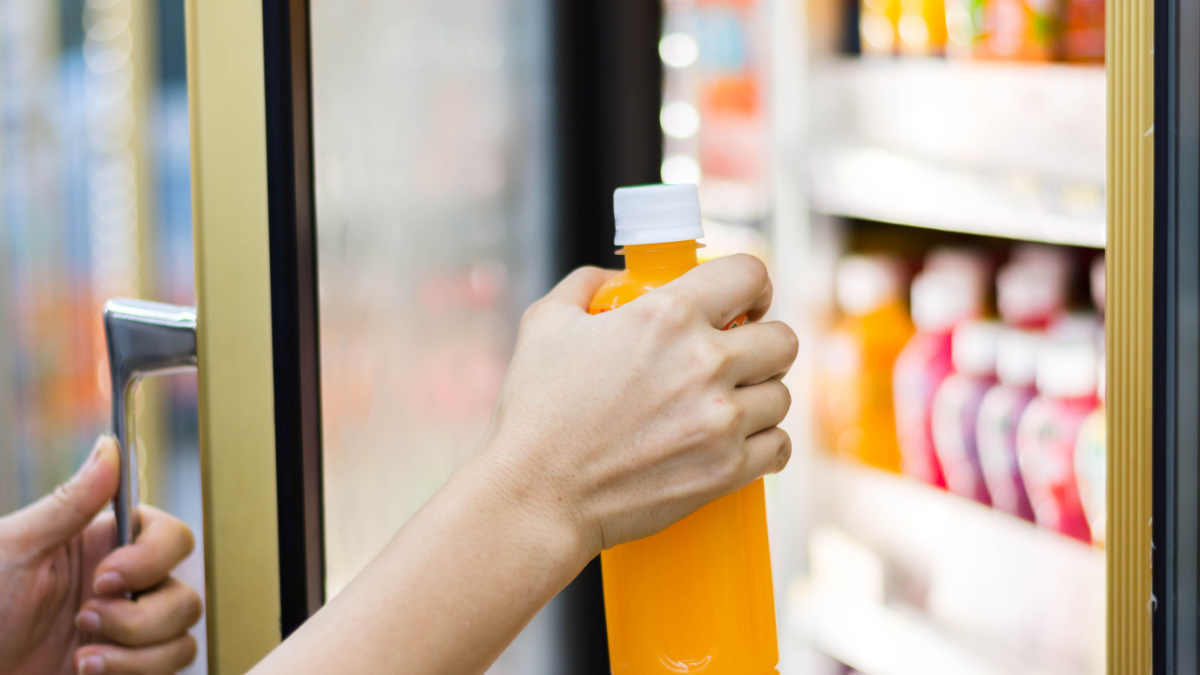 woman's hand open convenience store refrigerator shelves and pick product