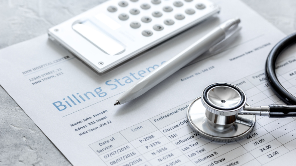 medical treatmant billing statement with stethoscope and calculator on stone background