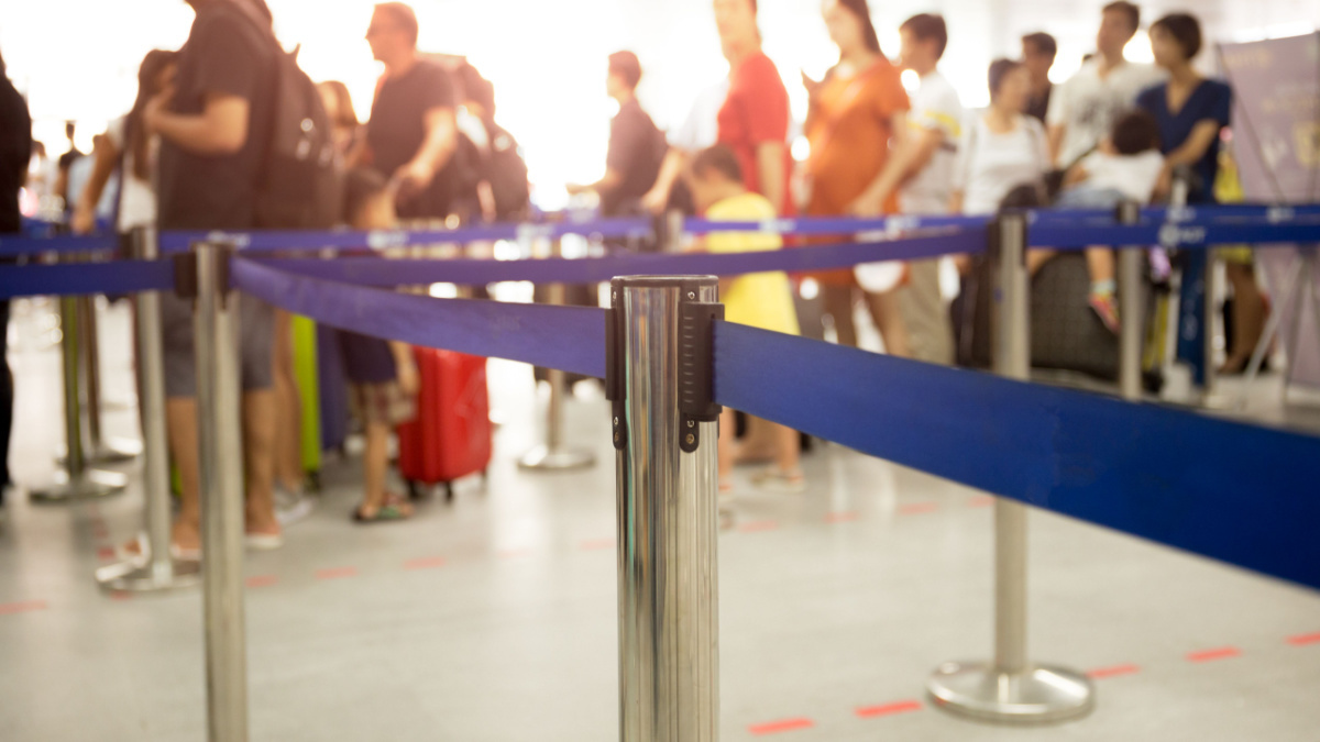 Passengers check-in line at the airport on vacation.