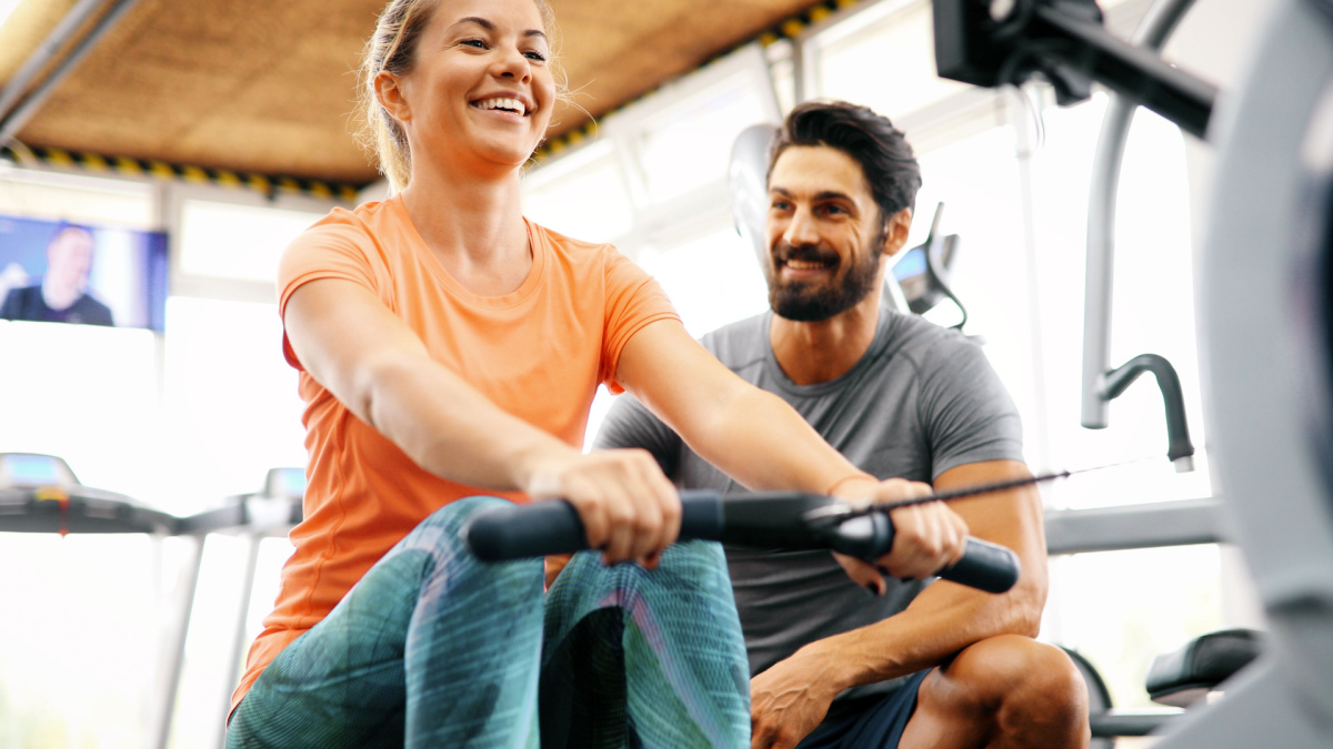 Young beautiful woman doing exercises with personal trainer