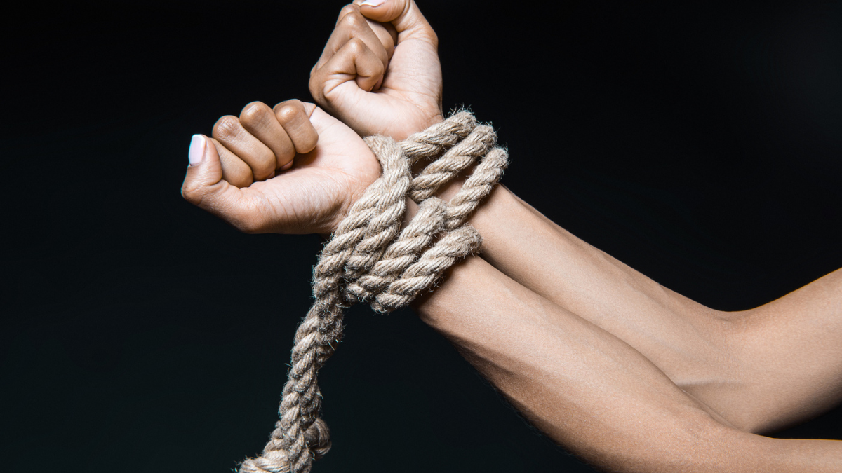 Female hands bound with rope.