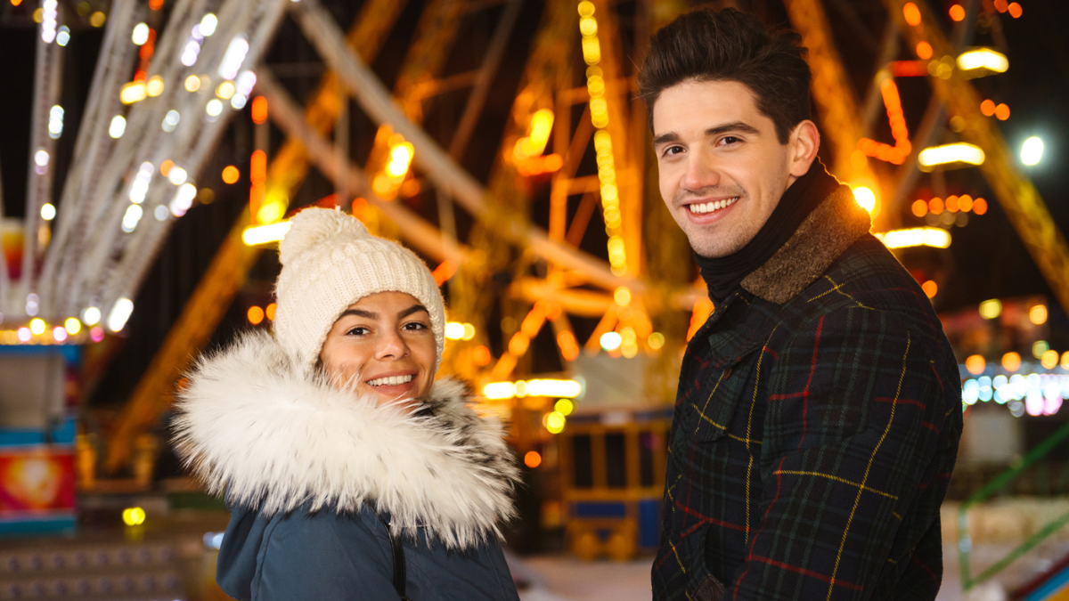 Happy cheerful young couple having fun at the ice skating park.