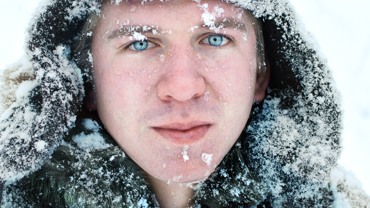Portrait of a blue-eyed Northern man in snow-covered clothes.