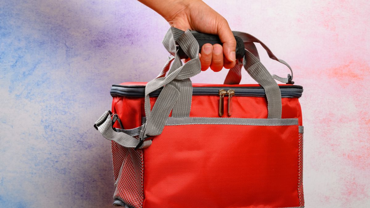 hand holding a red lunch pack carrier or insulation bag