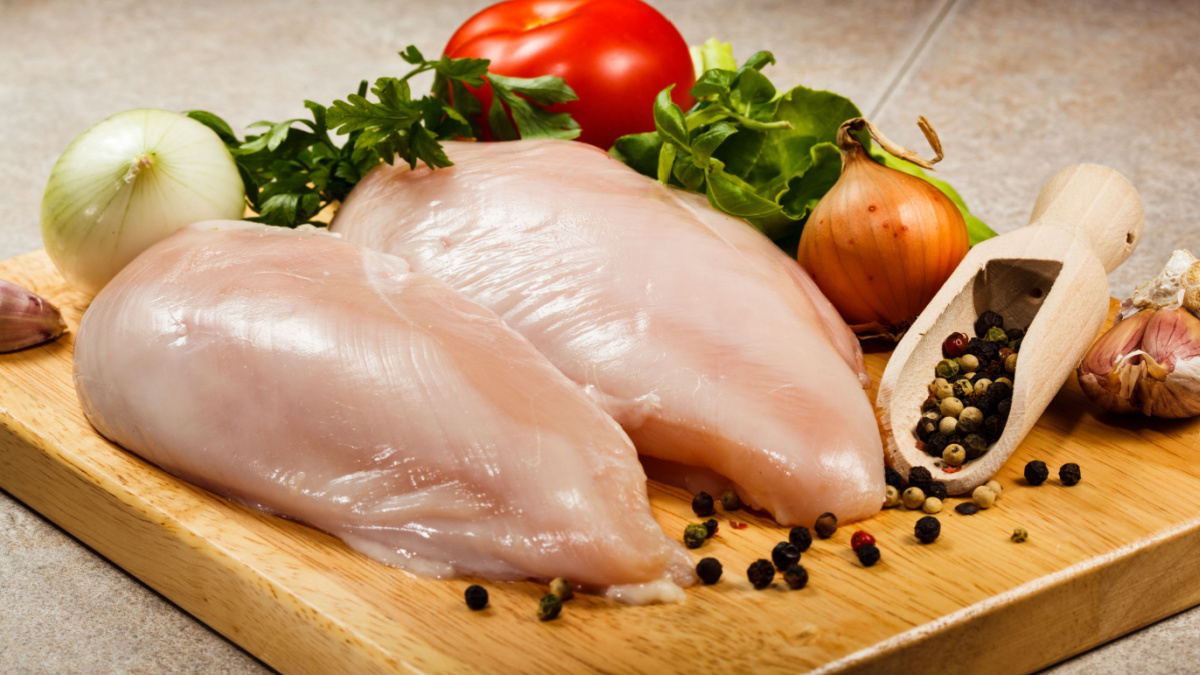 Raw chicken breasts on cutting board