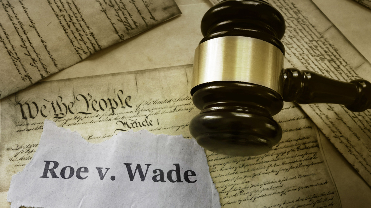 Roe v Wade news headline with gavel on a copy of the United States Constitution