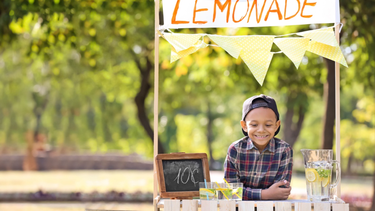 Little African-American boy at lemonade stand in park