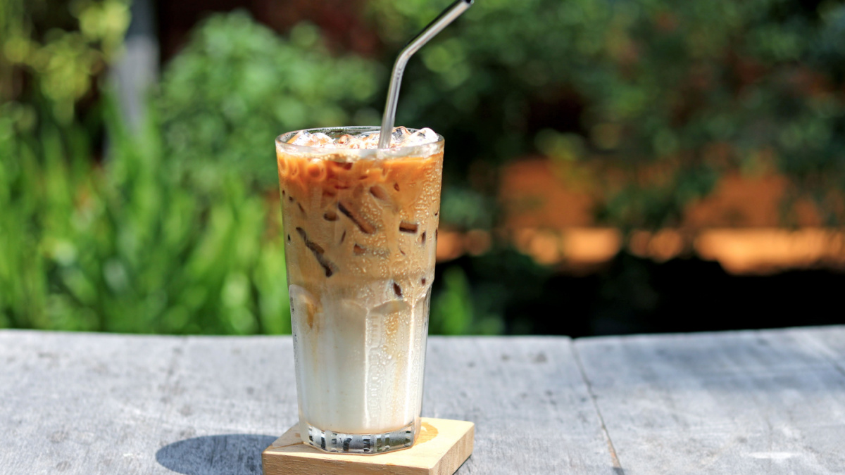 Iced caramel macchiato coffee in glass with stainless steel straw for drink. Concept for reduce plastic pollution and support green eco friendly products.