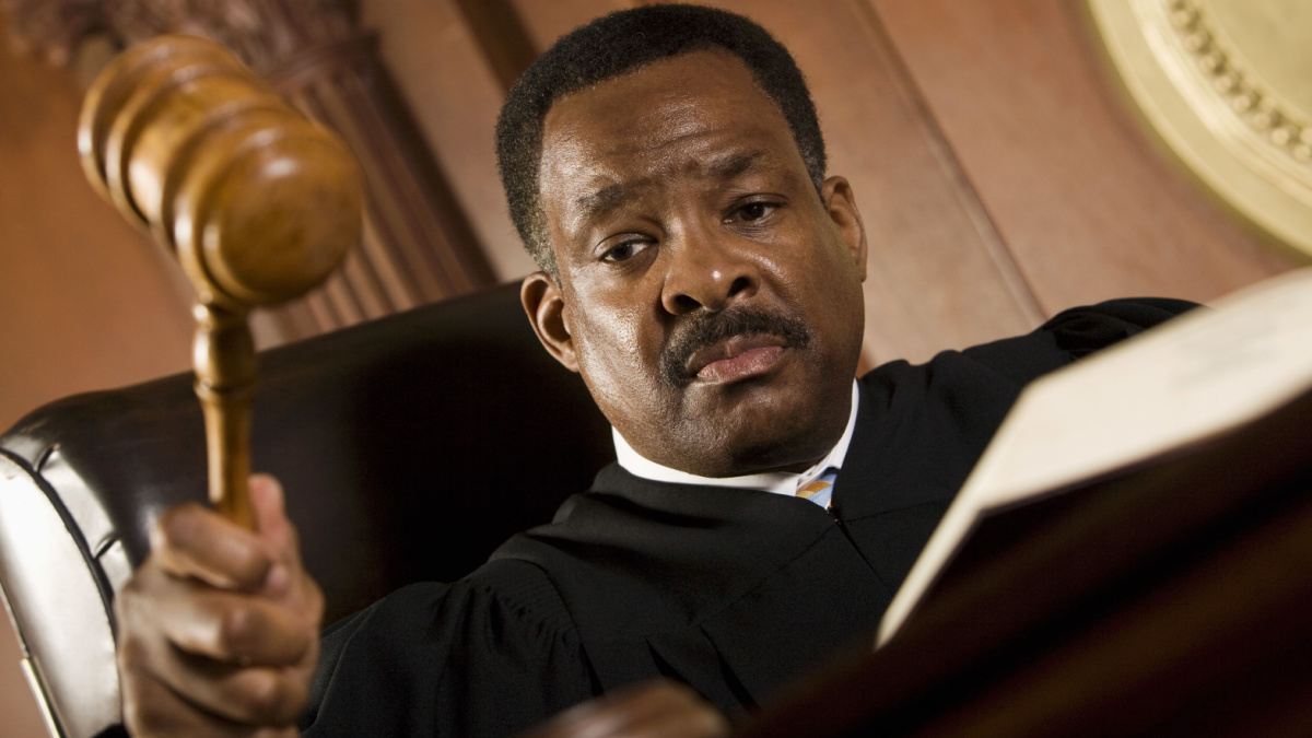 African American judge pounding mallet in courtroom.