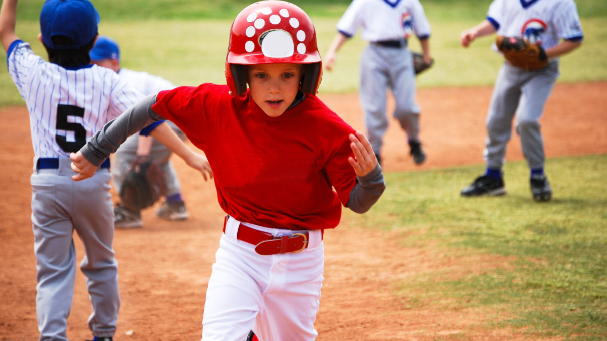 Youth baseball boy running bases.
