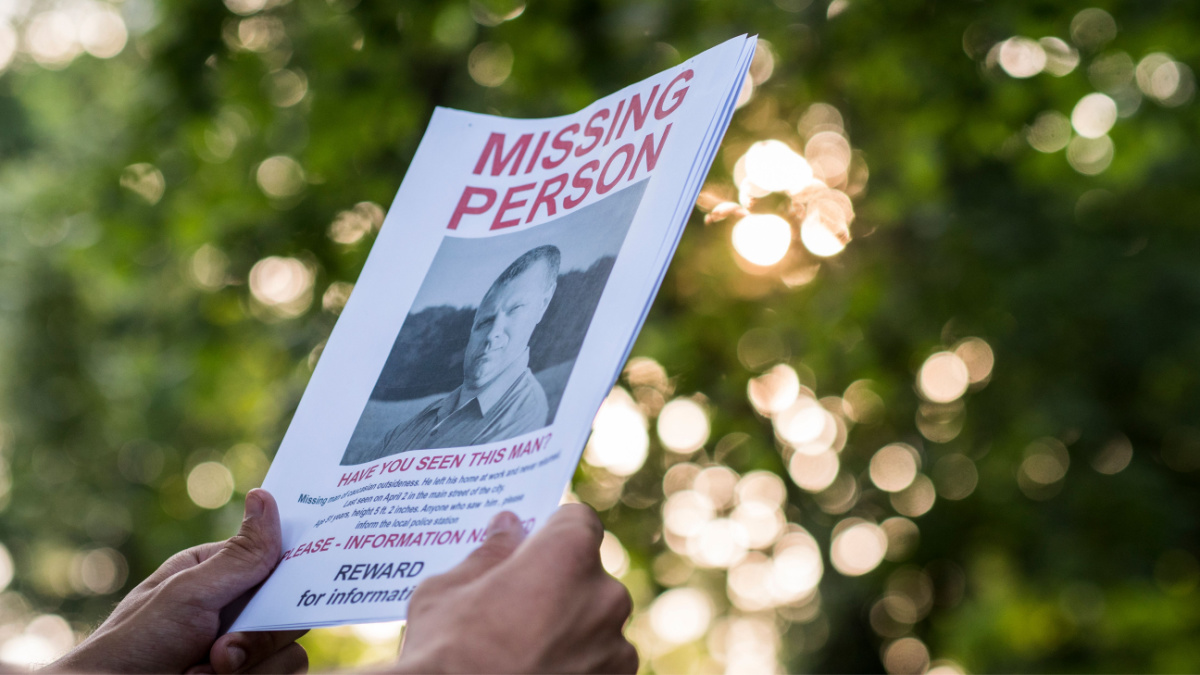 Man holding a flyer with the announcement of the missing man