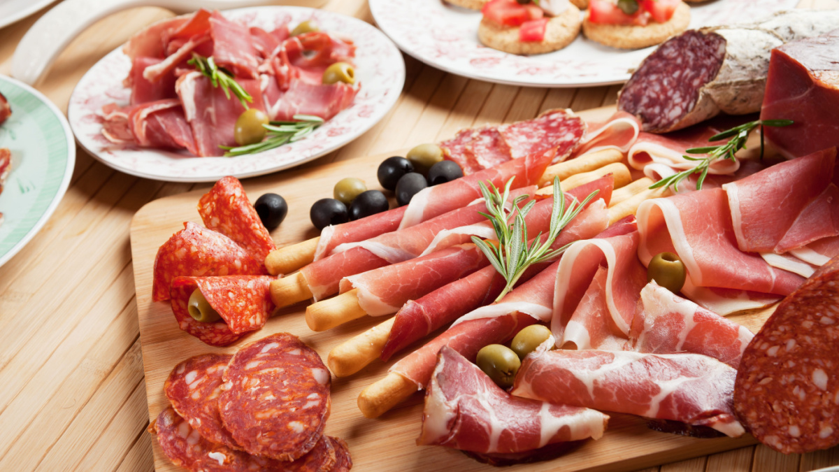 Italian prosciutto, cured pork meat on cutting board