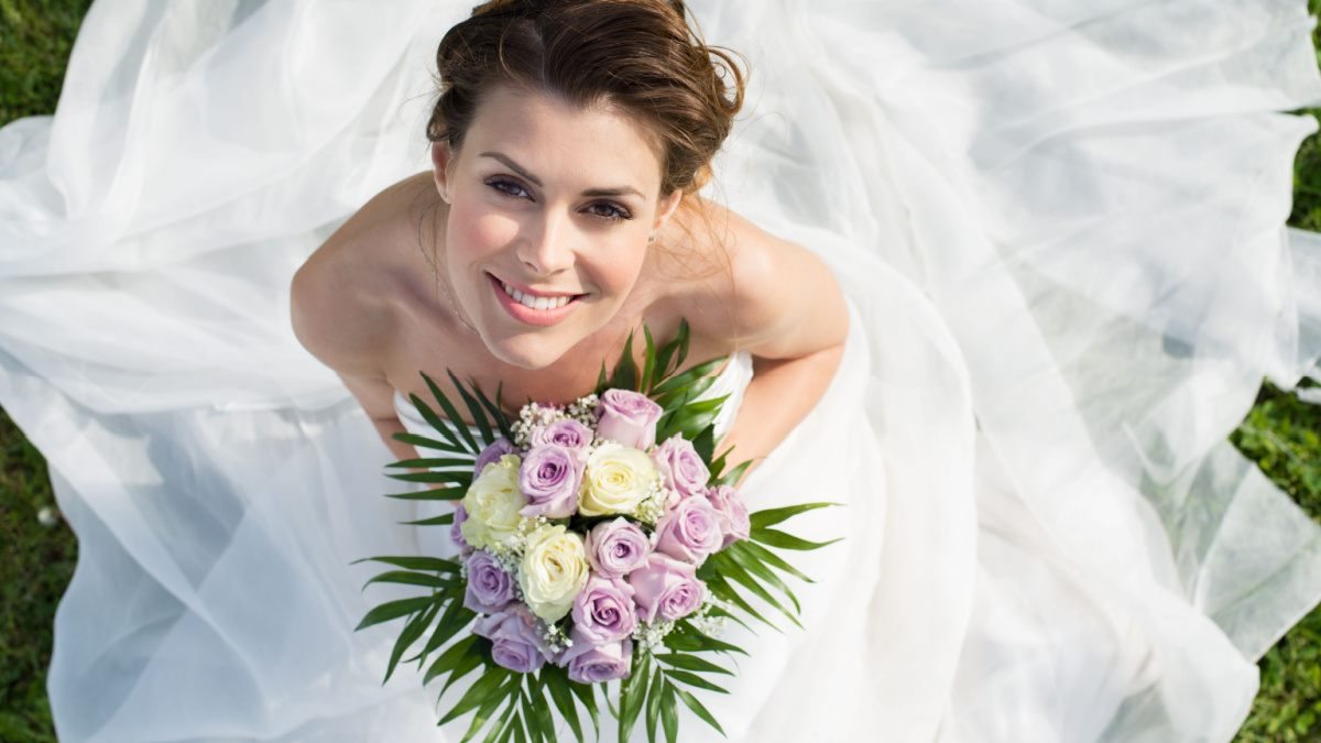 High View Portrait Of Beautiful Happy Bride Sitting On The Grass.