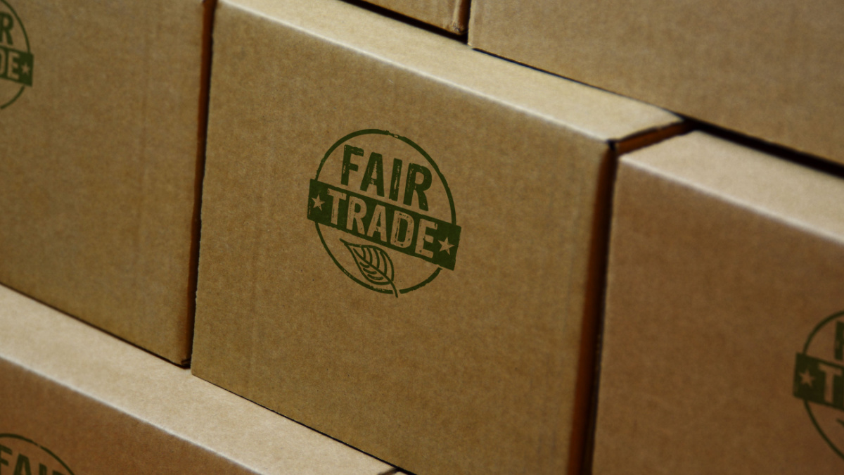 Fair Trade stamp printed on cardboard box. Ethical business, green trade, sustainable economy and environmental care concept.
