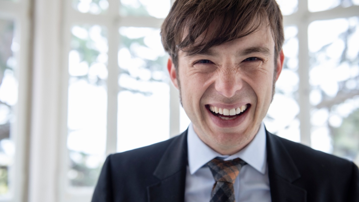 man in a suit laughing.