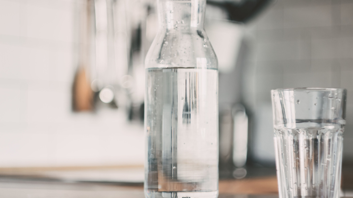 A carafe of water on the kitchen wooden table. Bottle of water. the concept of a healthy lifestyle