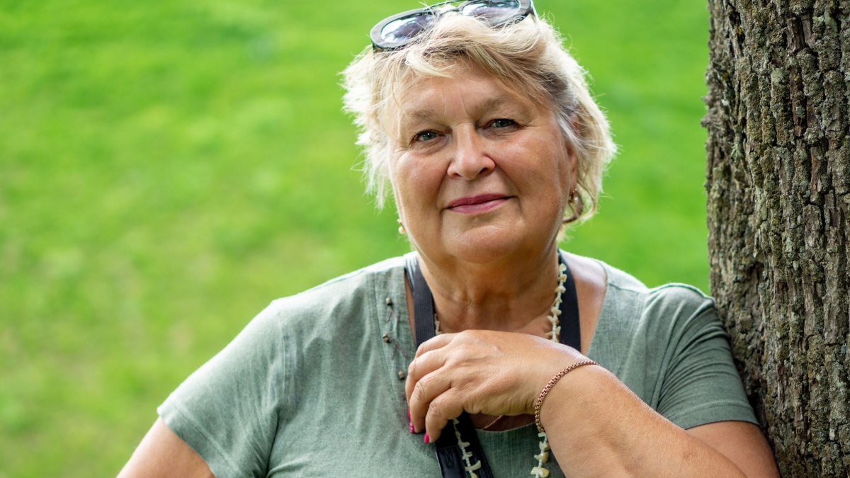 A cheerful Mature woman smiled at the photographer. Resting in the city Park.