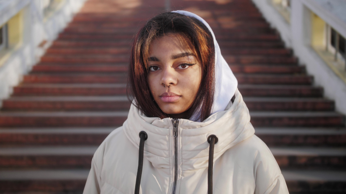 Portrait of confident young black woman looking serious at camera. Independent african american female on the city background.