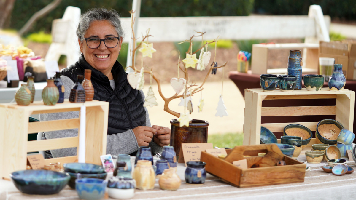 San Diego Vintage Collective Art and Craft Show booth Dec 5 2021 woman with pottery display selling her ceramic bowls, vases, dishes, and ornaments at the crafts fair