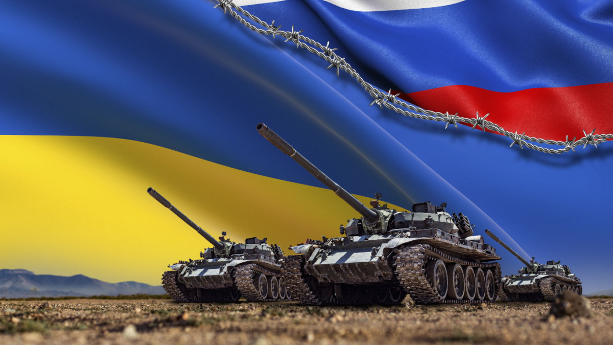 A Group of tanks lined up in front of Russian and Ukrainian flags. Several military army war battle tank vehicles on the terrain are ready to attack. Russian-Ukrainian conflict or war