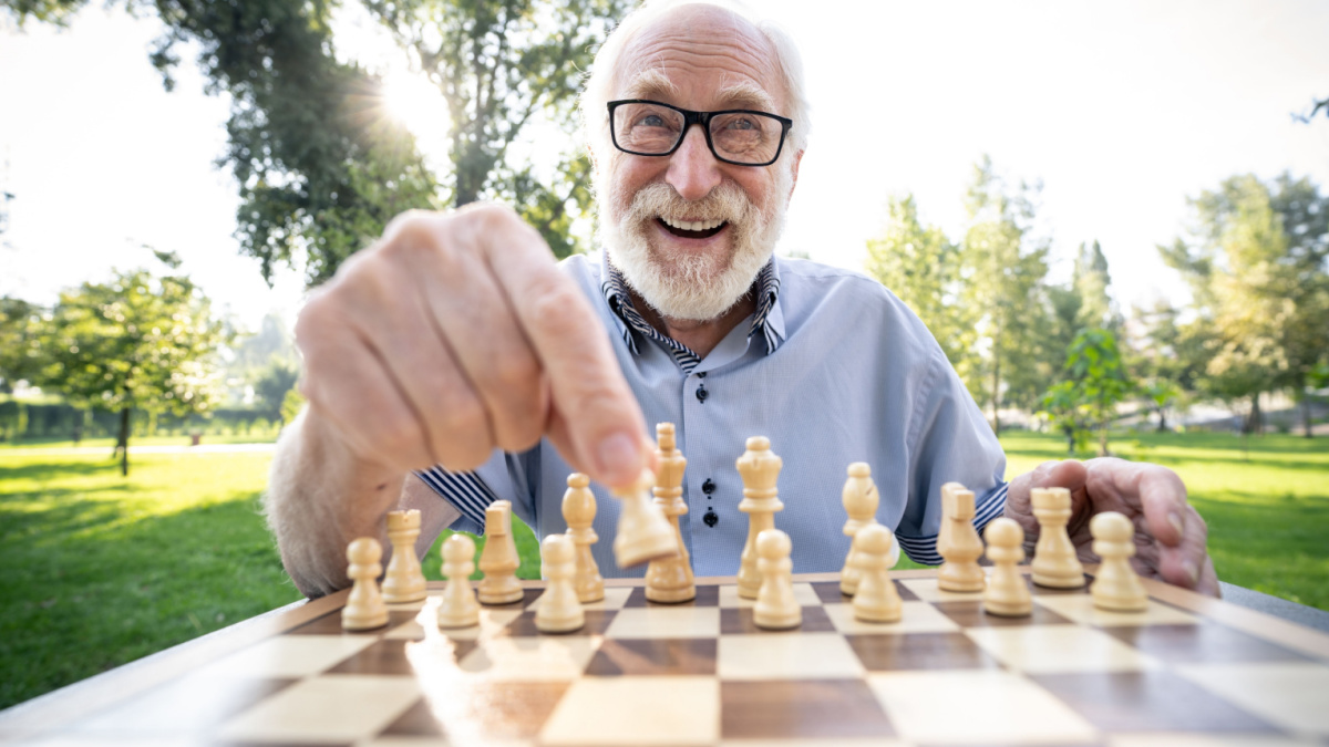 Group of senior friends playing chess game at the park. Lifestyle concepts about seniority and third age