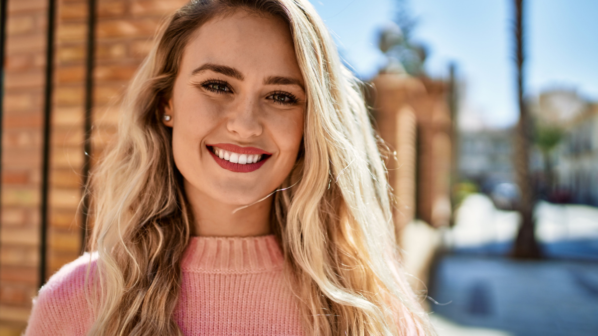 Young blonde woman smiling at the city.