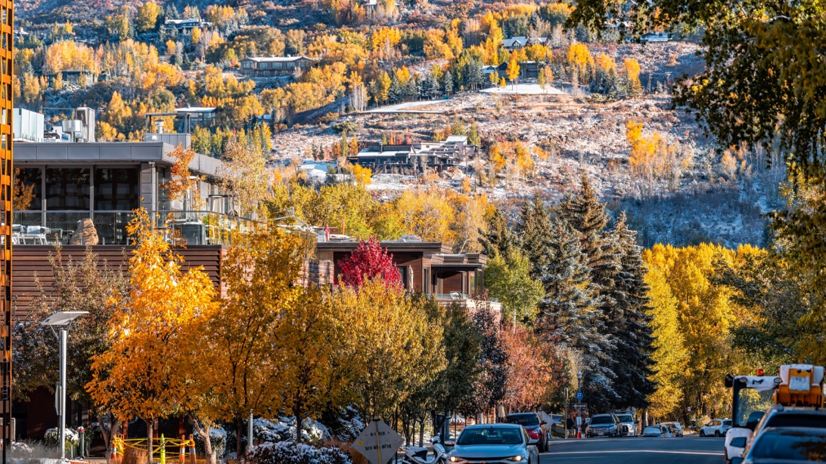 Main street road in ski resort town city of Aspen, Colorado in fall autumn or winter with snow by luxury houses homes