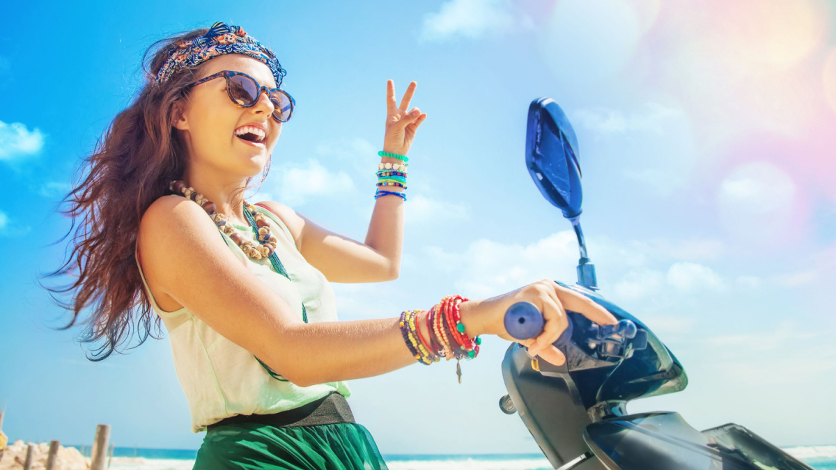 optimistic pretty hippie woman riding her motorbike.