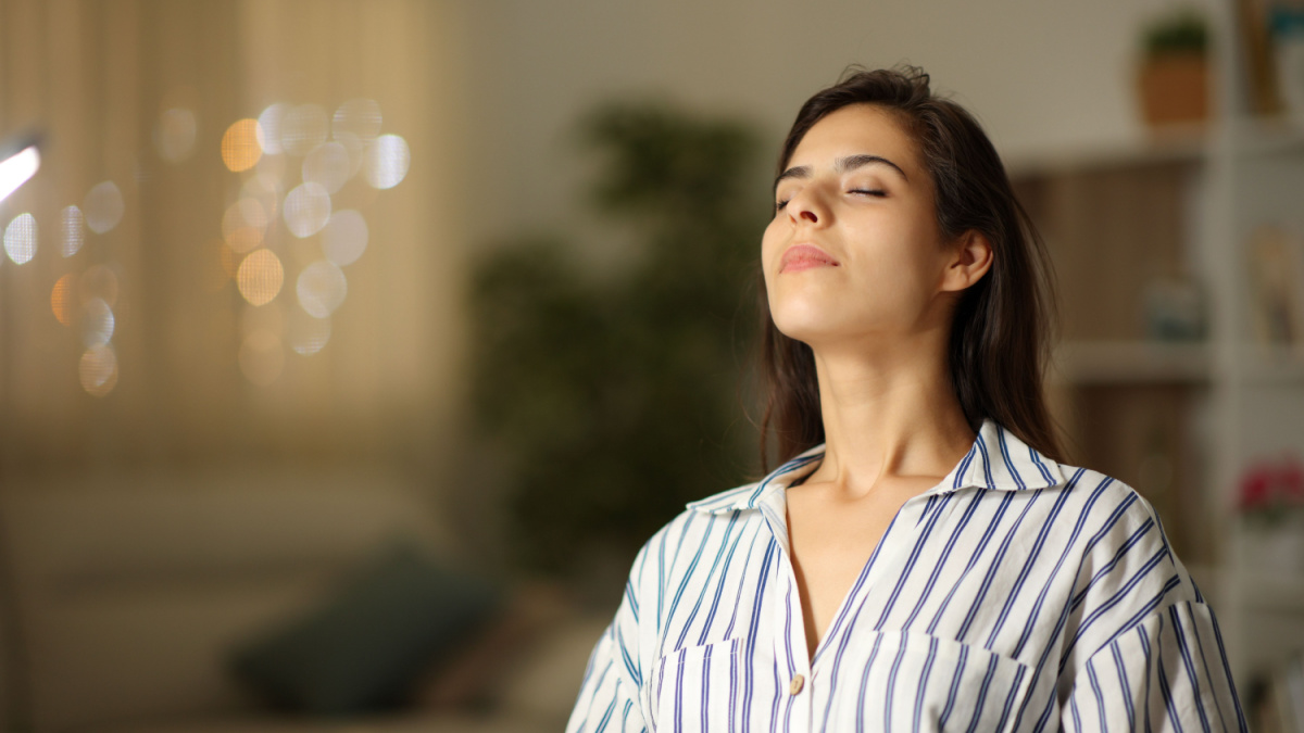 Satisfied woman breathing sitting at home in the night