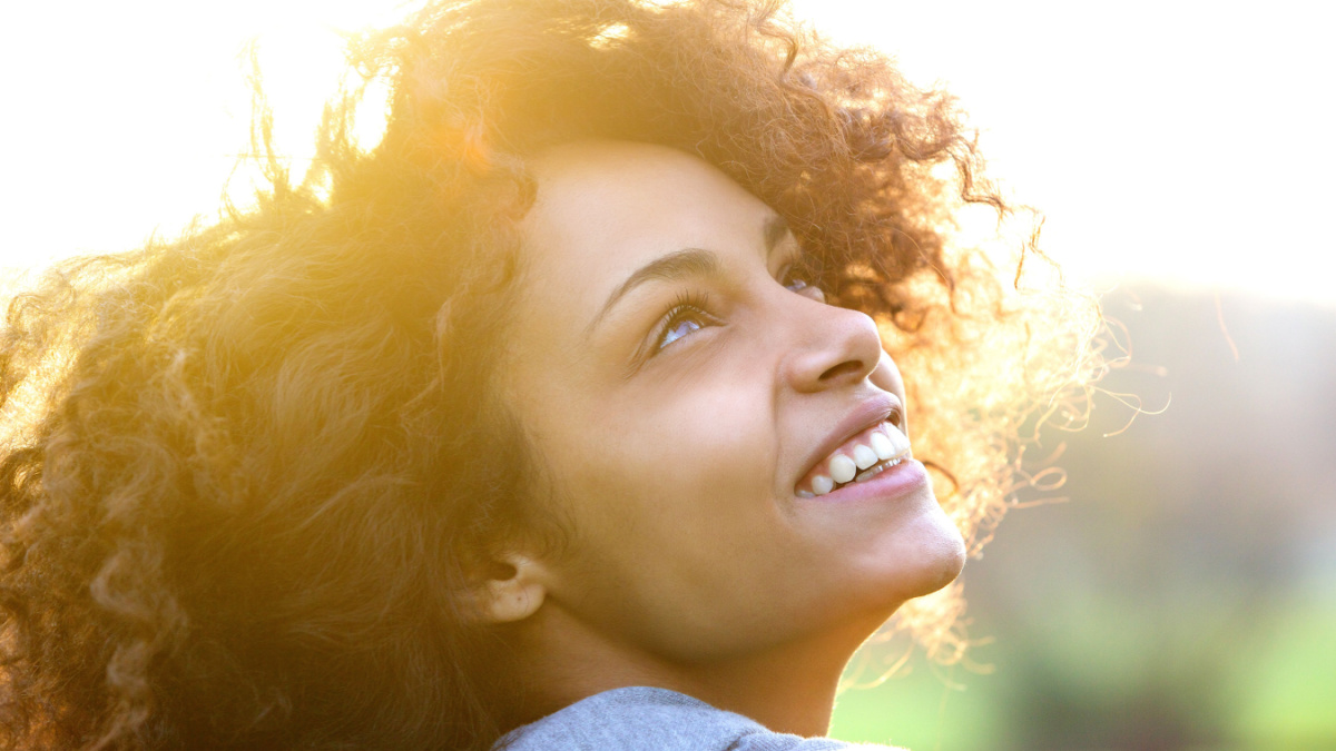 Close up portrait of a beautiful young african american woman smiling and looking up.