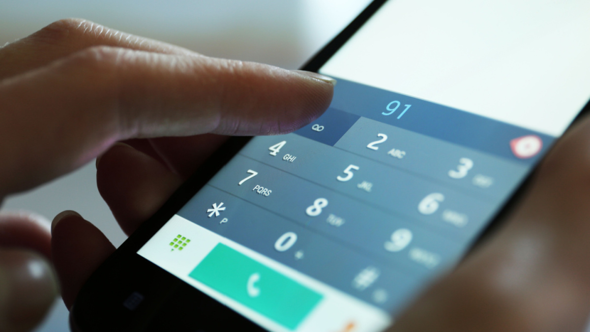 Finger touch number on smartphone to make a call, close up