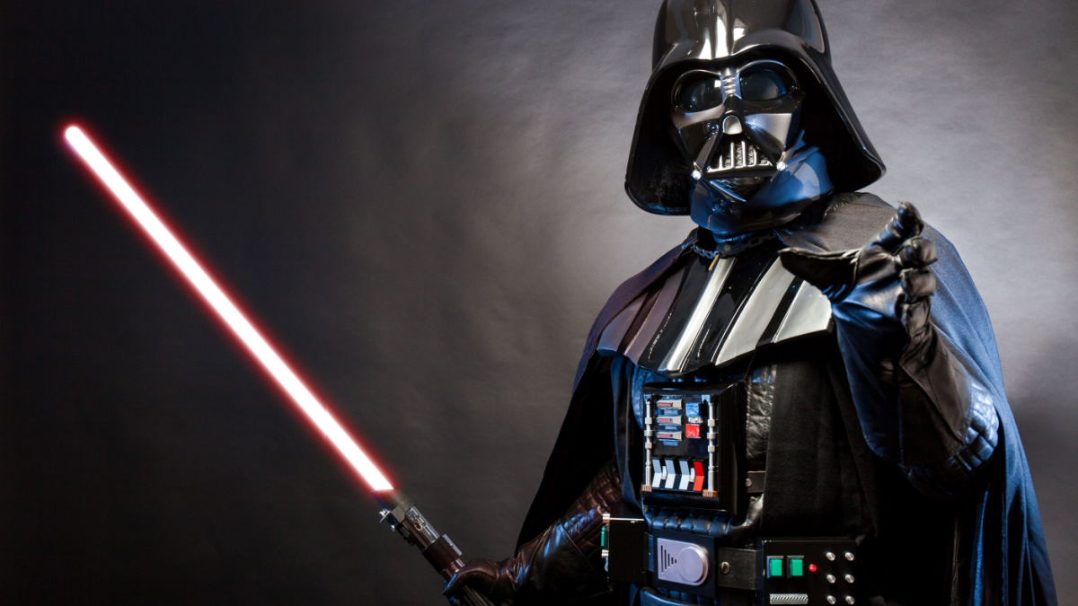 Portrait of Darth Vader costume replica with grab hand and his sword . Lord Fener is a fictional character of Star Wars saga. Blue grazing light