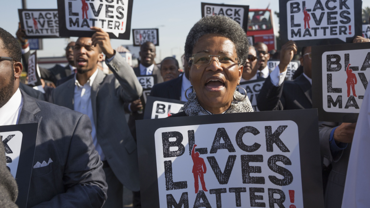 30th annual Martin Luther King Jr. Kingdom Day Parade, women hold sign