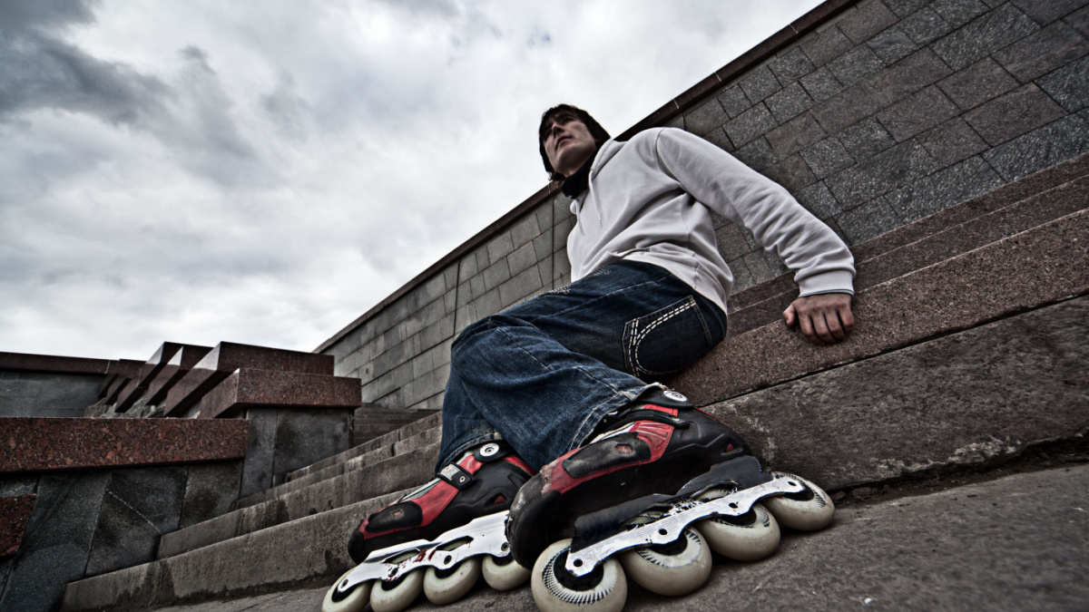 Wide angle portrait of a serious rollerskating man
